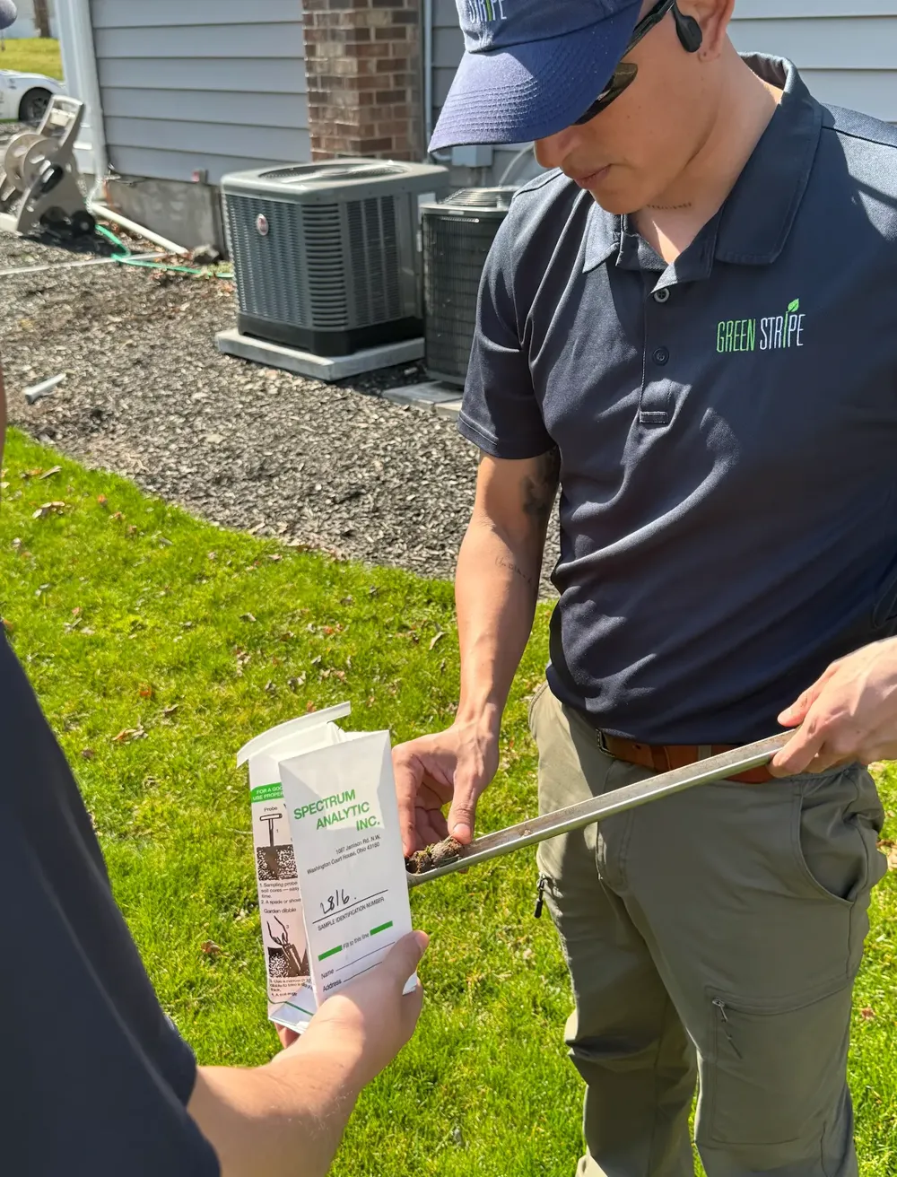 GreenStripe technician placing a soil core into a laboratory sample bag on a Northern New Jersey lawn